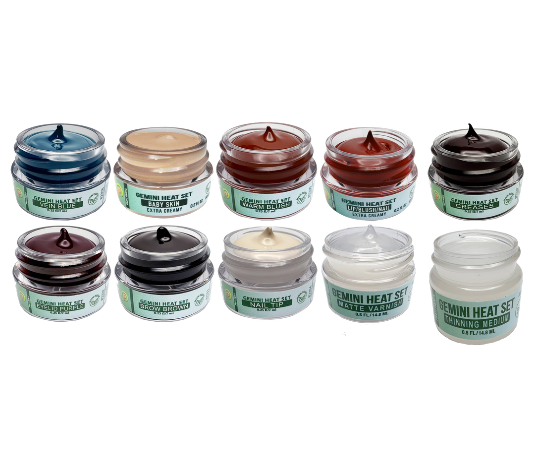 Set of small jars with various colors on a white background